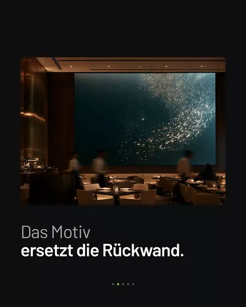 Feed-Slide: Lounge, in der eine leuchtende Wand die Rückwand ersetzt, darüber „Das Motiv ersetzt die Rückwand."