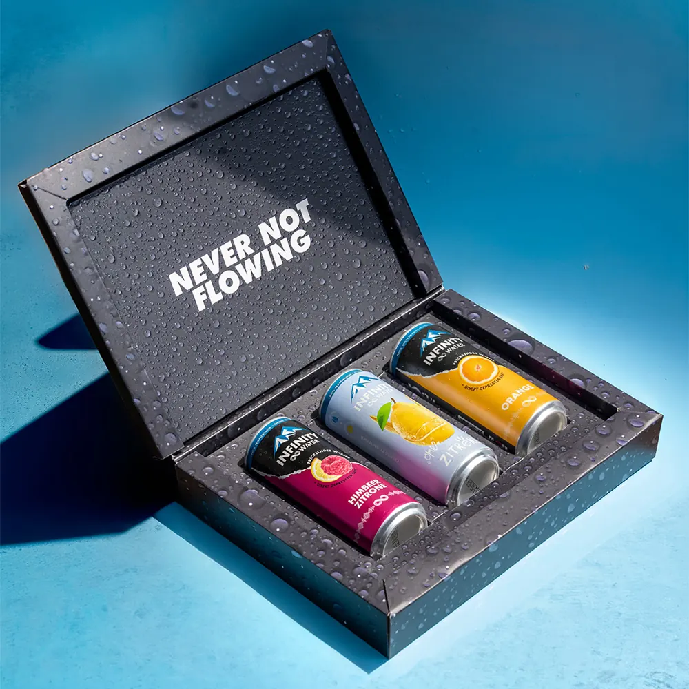 Geöffnete schwarze Box mit drei Dosen, im Deckel der Schriftzug „Never not flowing“