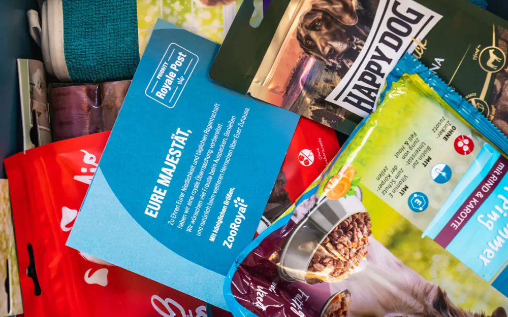 Bunte Futterbeutel neben einer blauen Karte mit der Aufschrift „Eure Majestät“